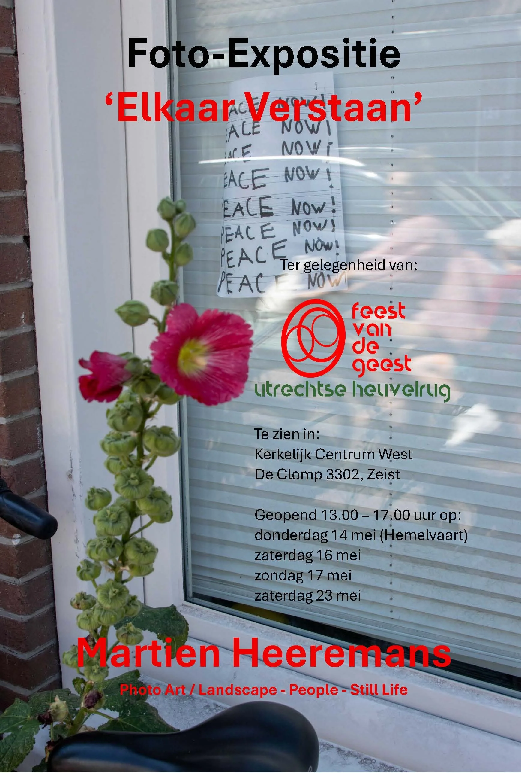 A flower stalk with green buds and pink flowers next to a window with a sign. The sign has black and red text advertising a photo exhibition titled 'Elkaar Verstaan' by Martien Heermans, including dates and opening hours in Dutch.