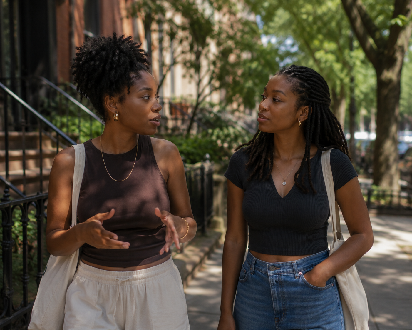 Two Black women having a meaningful conversation while walking together, illustrating the role of curiosity and communication in maintaining emotional connection.