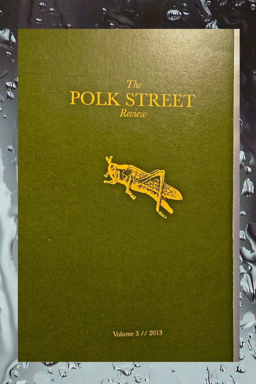 Book cover is dark green with golden print and features a hopping grasshopper