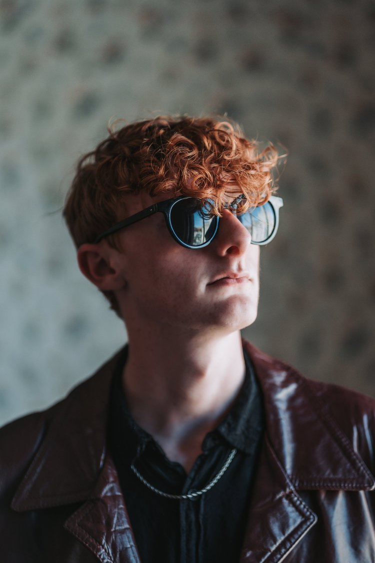 Portrait of a young man wearing sunglasses and a leather jacket