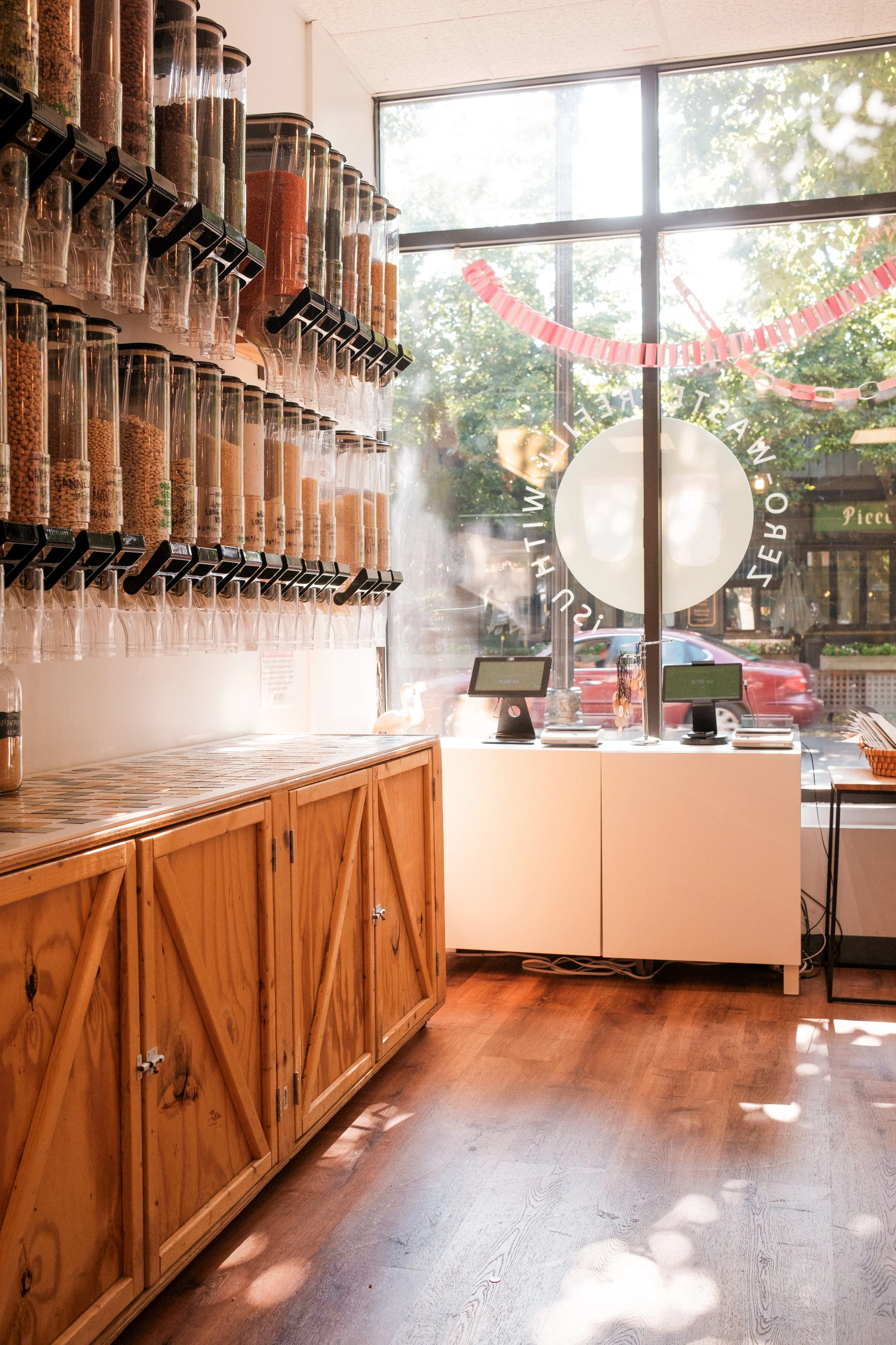 Interior of a store with wooden cabinets and large containers filled with spices or dried goods.