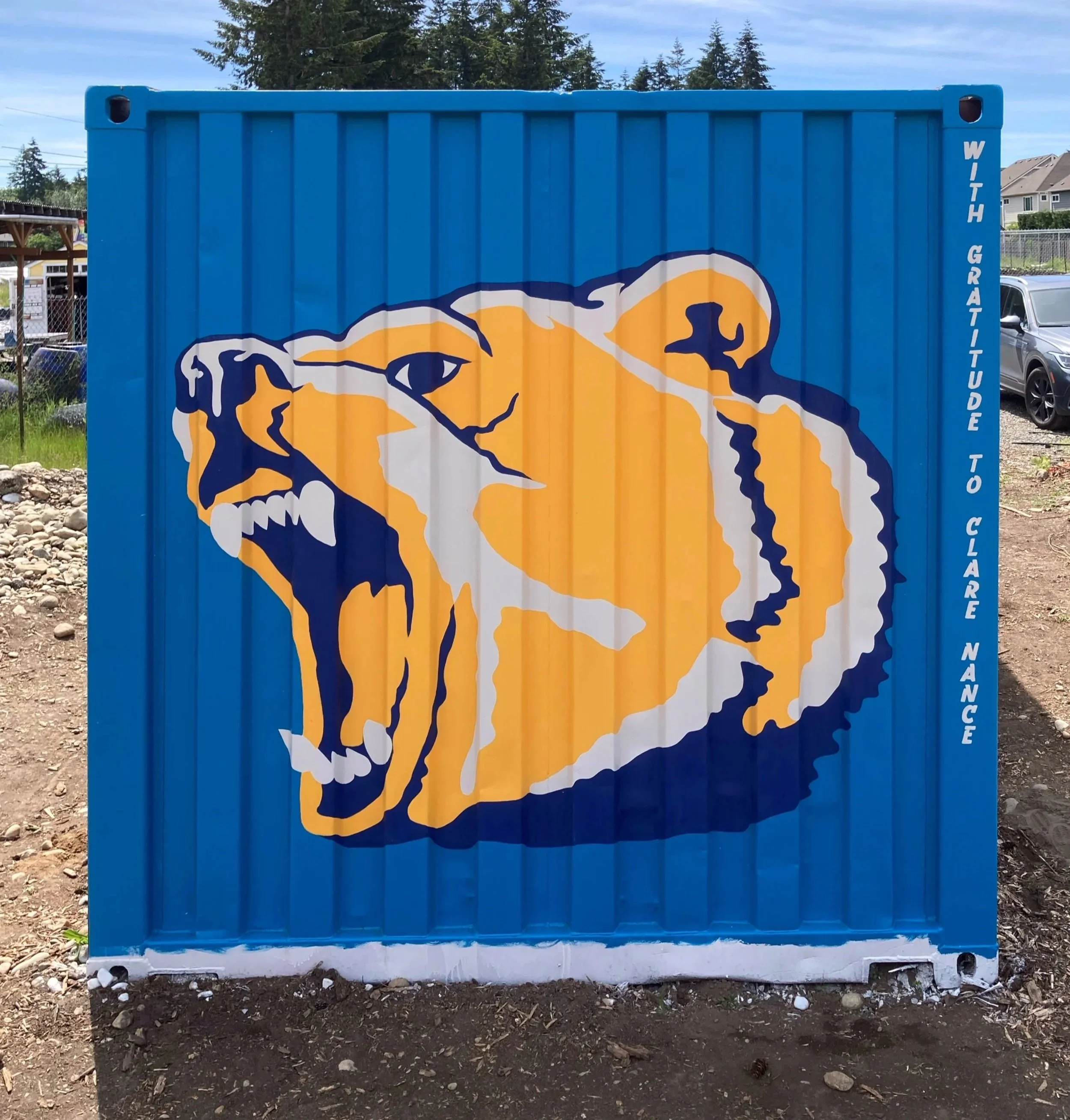 Mural of the Tahoma High School Mascot painted Elk Run Farm's shipping container to honor Clare Nance. Shelly Metzger Acorn Murals, Maple Valley. Bear is gold, blue, and white.
