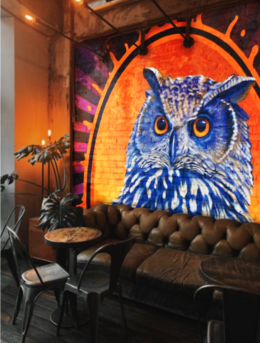 Lounge area with a large owl mural concept on a brick wall, leather sofa, round tables, metal chairs, and plants. Created with Shelly Metzger's fine art painting Night Owl Coffee @AcornMurals #AcornMurals