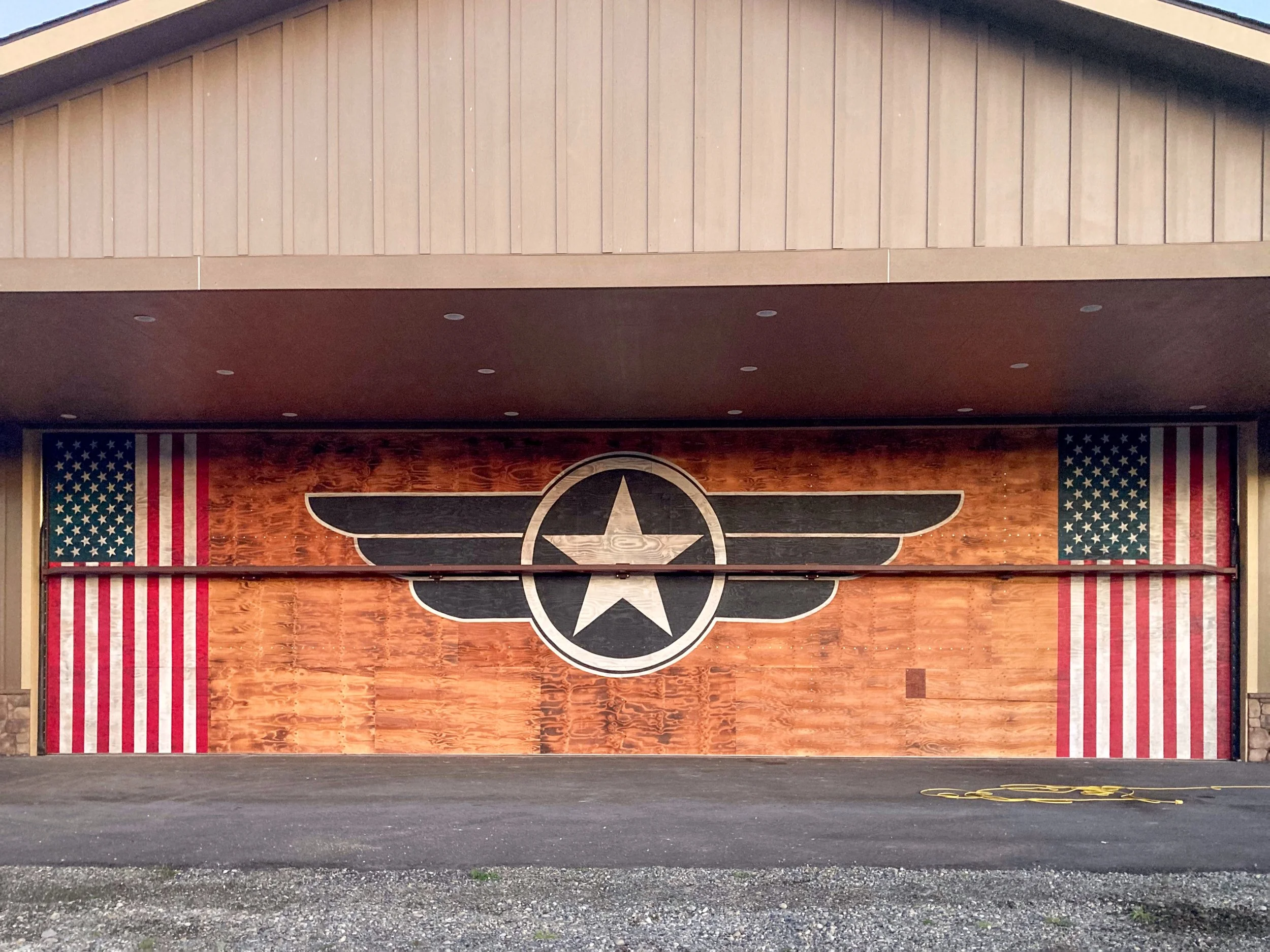 Americana Mural Painted on an Airplane Hanger Door Two American Flags, with a stylized Airforce Logo @AcornMurals #AcornMurals