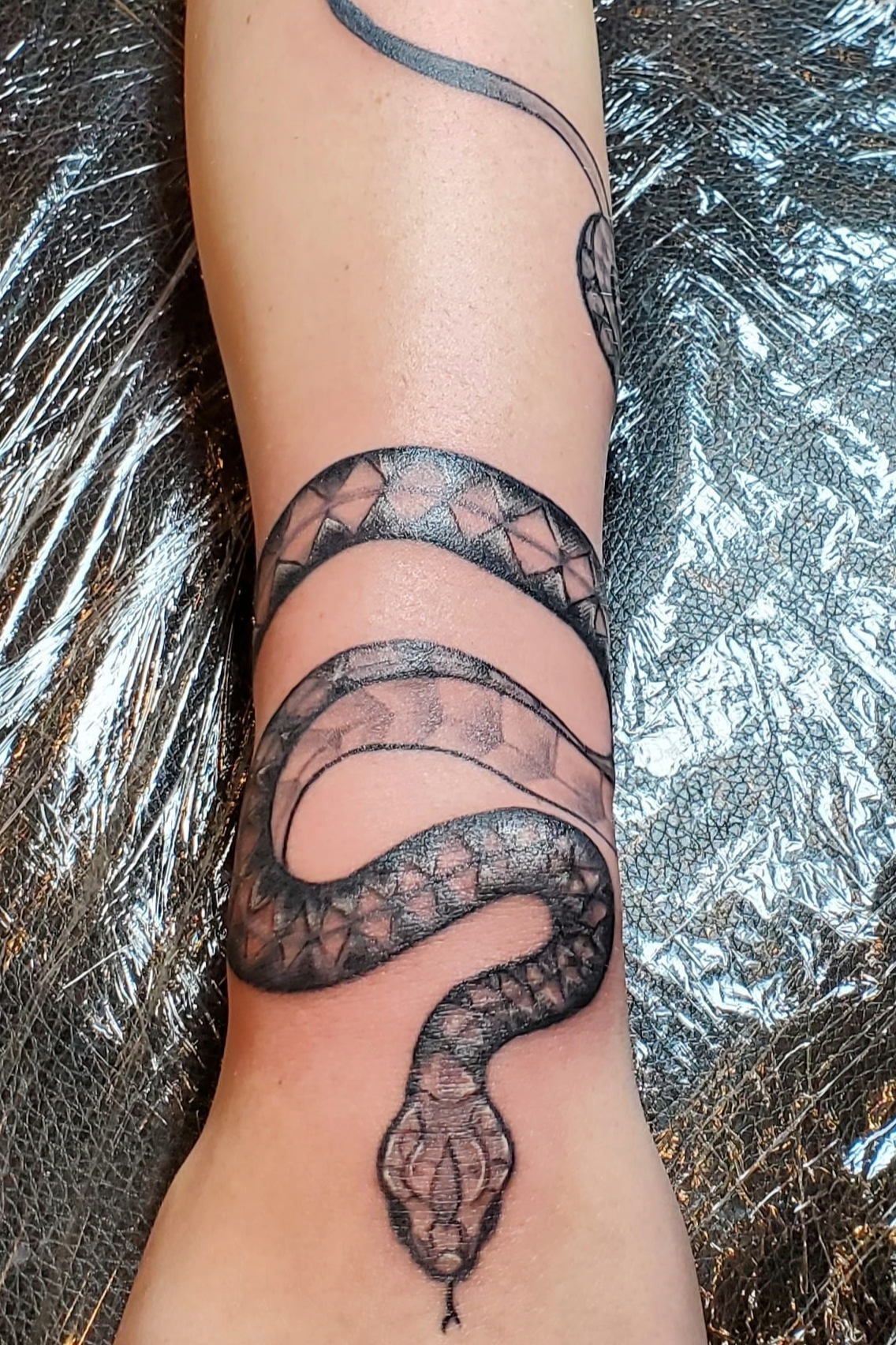 snake tattoo curling around wrist