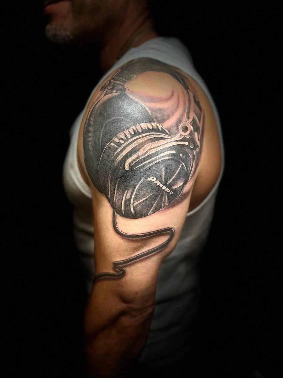 Tattoo of a loudspeaker on a person's upper arm.
