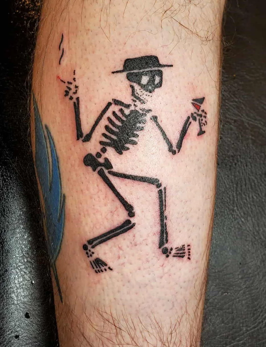 Dancing skeleton holding a drink and a cigarette tattoo done by a Redding tattoo artist