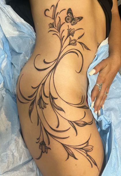 fine line floral tattoo on side hip