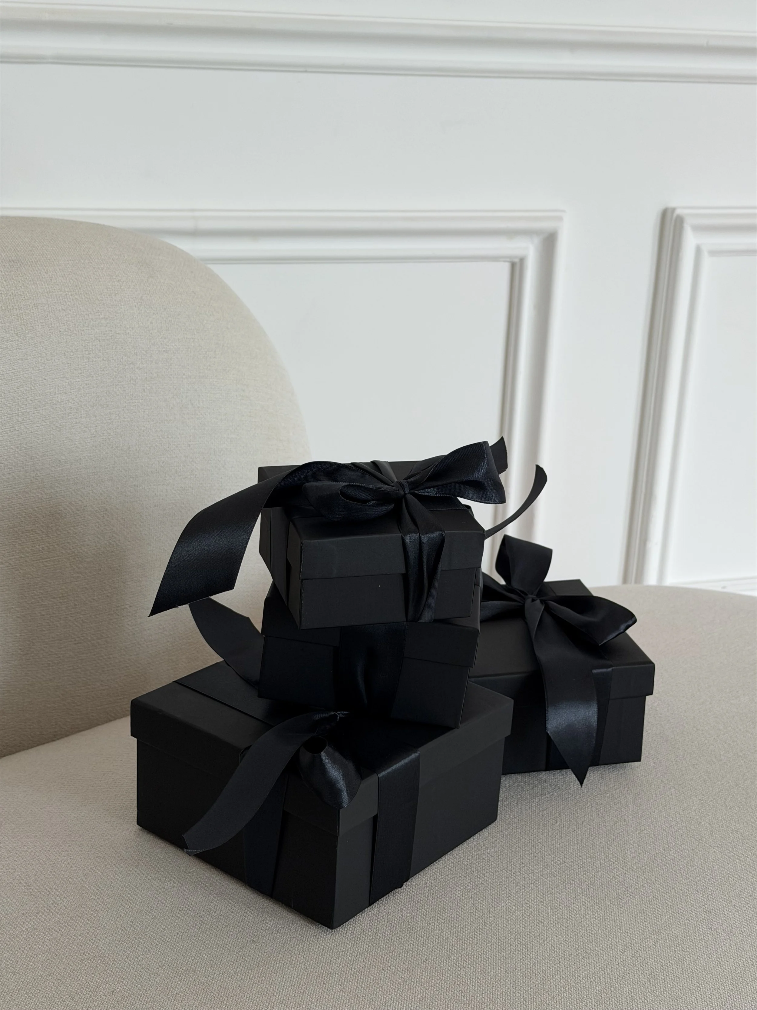 Close-up of stacked black gift boxes with satin bows for Black Friday