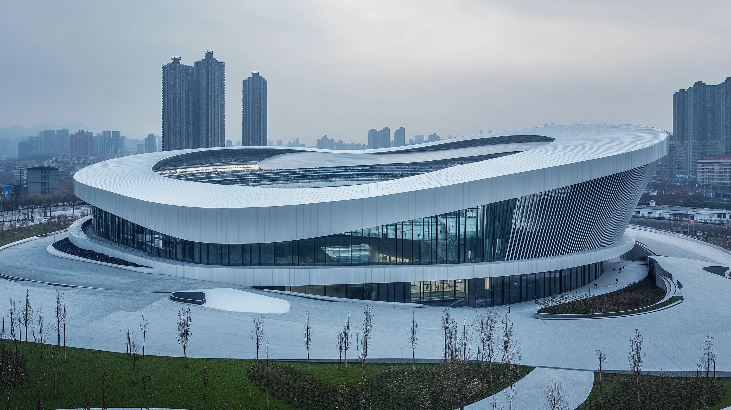 Futuristic building with a curved design, large windows, and surrounded by high-rise buildings in the background.