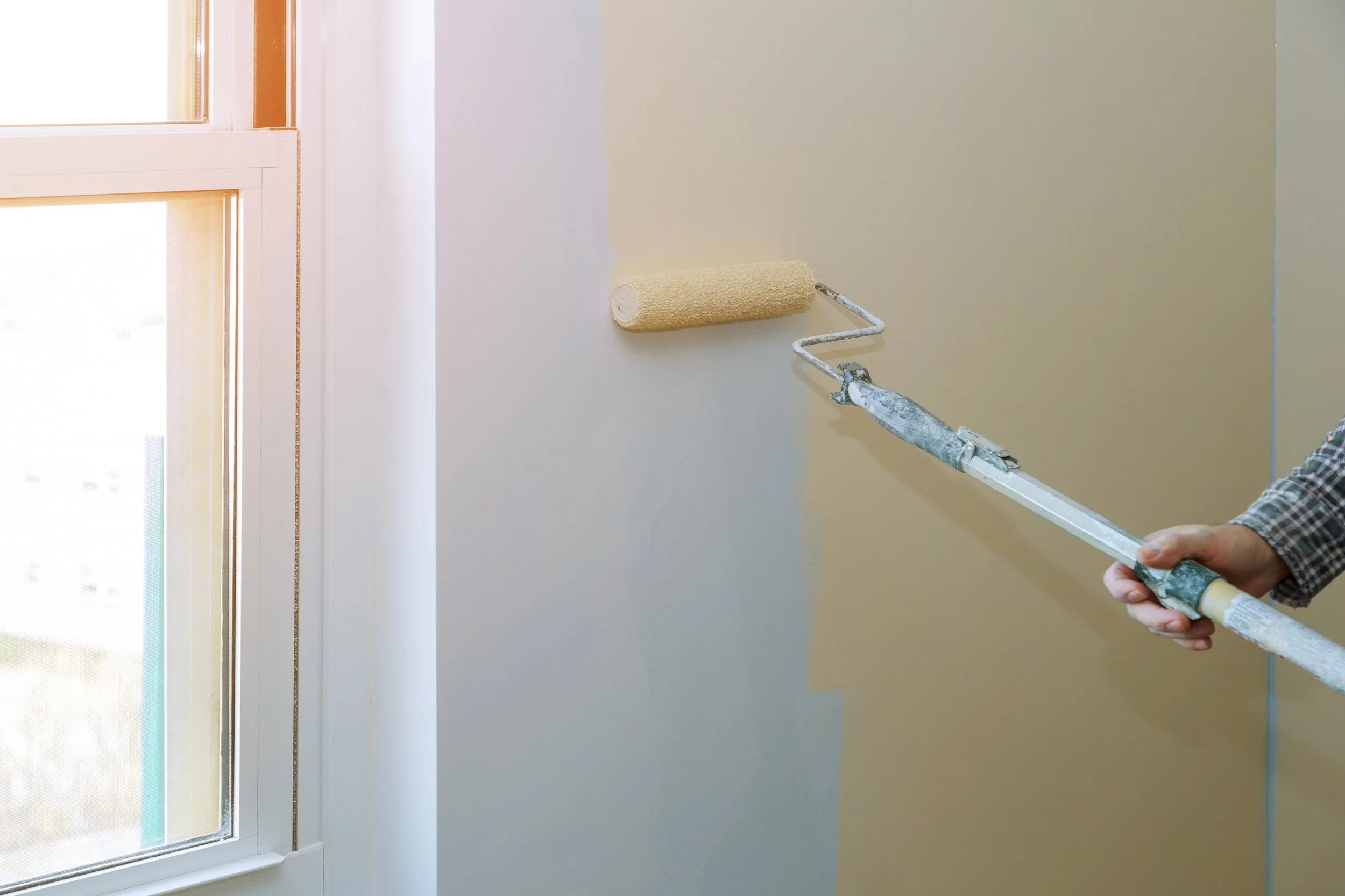 A man painting an interior of a home in Marquette, Michigan