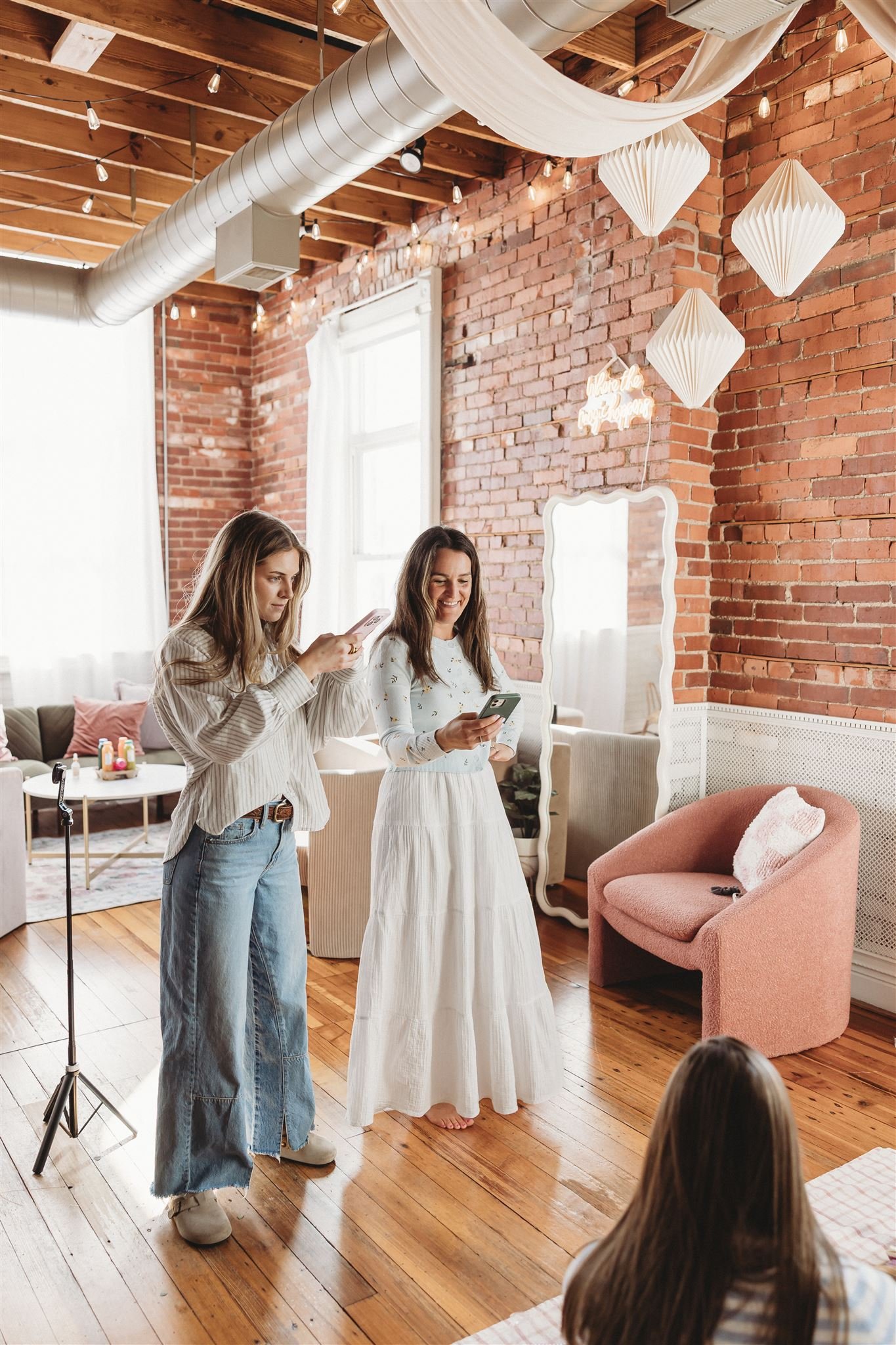 Mountains with snow-covered peaks under a cloudy sky, with a modern house in the foreground on a grassy hill.