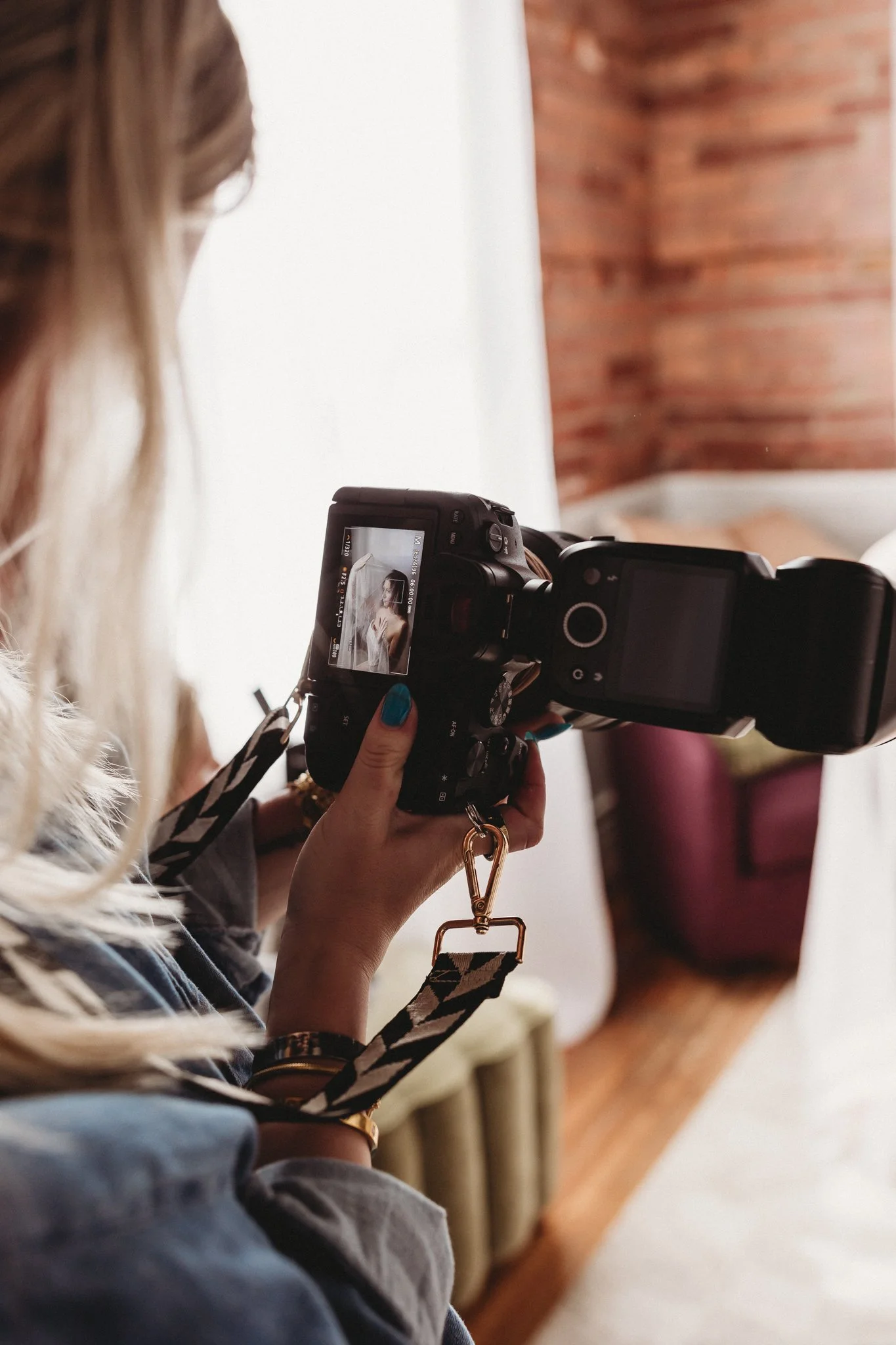 Scenic view of a turquoise lake surrounded by grassy hills and distant mountains under a cloudy sky.