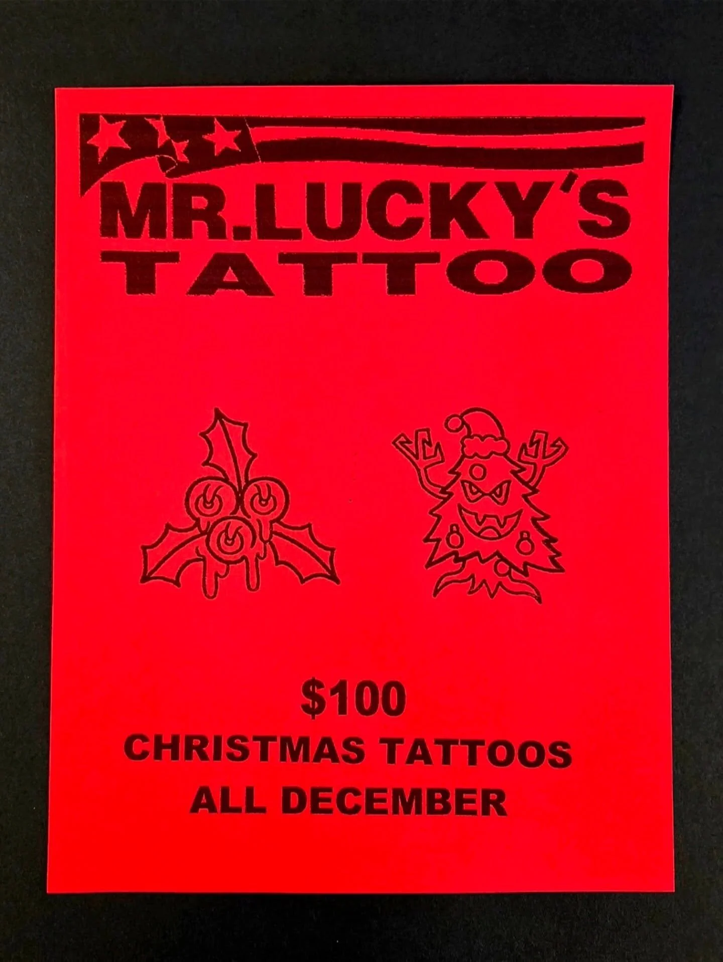 Red flyer advertising Christmas tattoos for $100 at Mr. Lucky's Tattoo, available all December. The flyer features Christmas-themed line art, including holly and a decorated Christmas tree with a Santa hat.