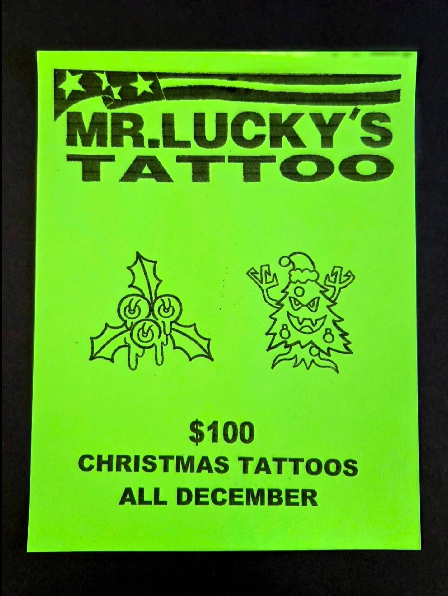 Bright yellow-green flyer advertising Christmas-themed tattoos for $100 available all December, with illustrations of holly and a holiday creature with antlers and a Santa hat.