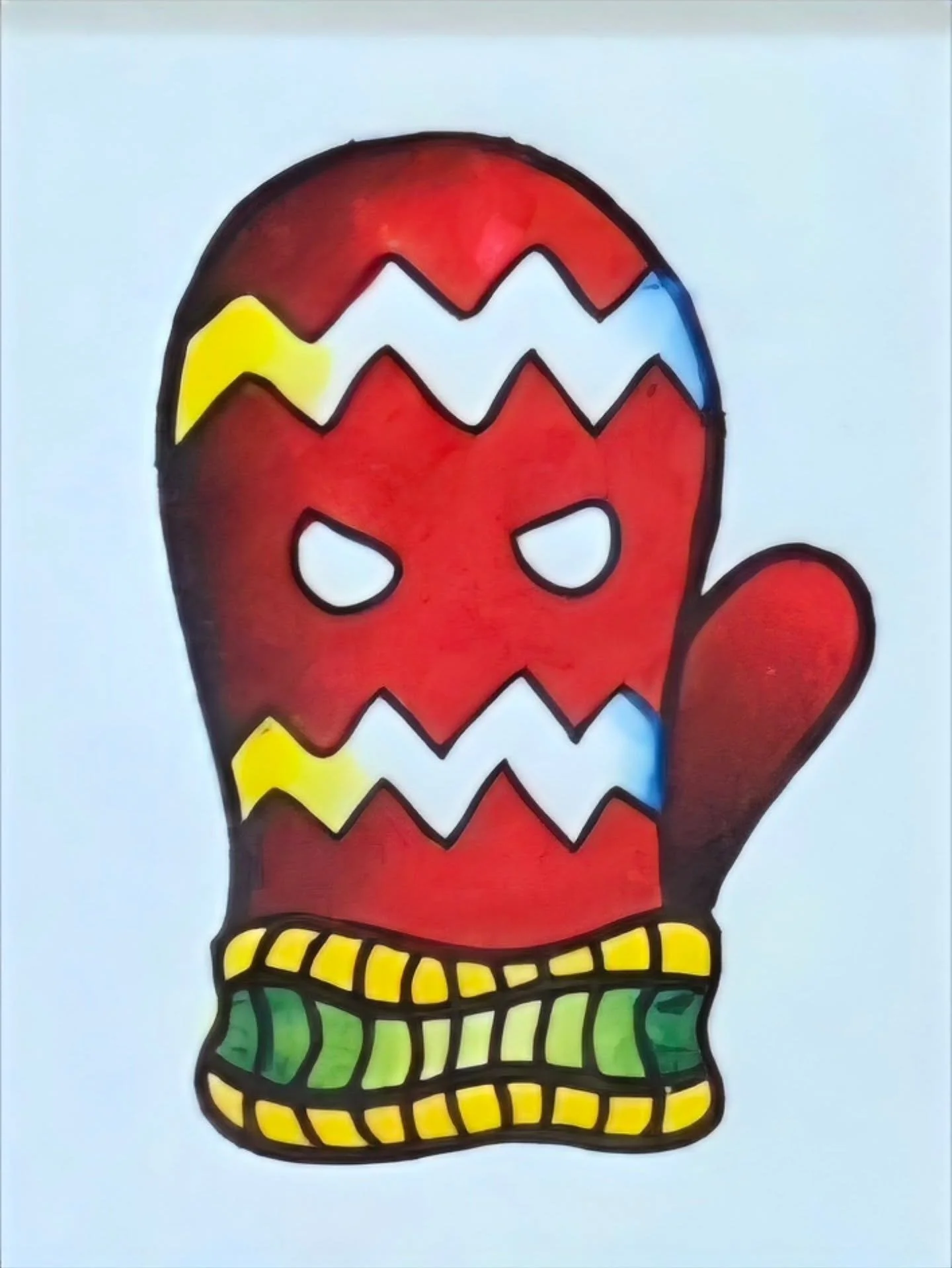 Drawing of a red oven mitt with a face, featuring angry eyes and jagged white teeth pattern, wearing a green and yellow checkered cuff.