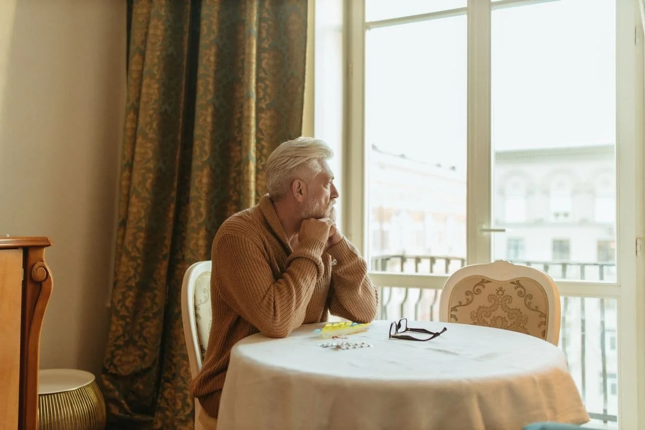 elderly-man-in-brown-sweater-sitting-on-chair
