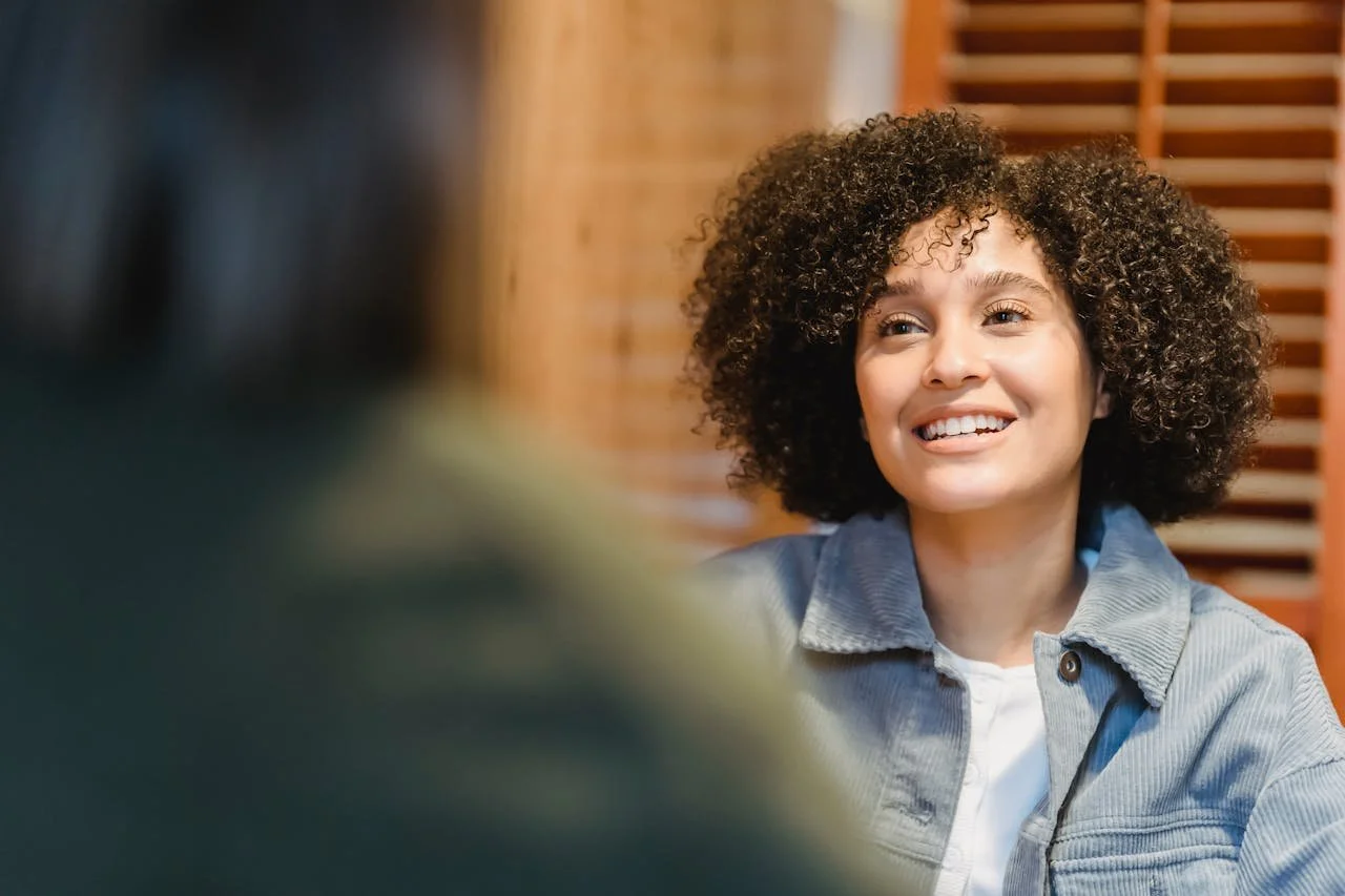 cheerful-young-woman-with-afro-hairstyle-talking-with-friend