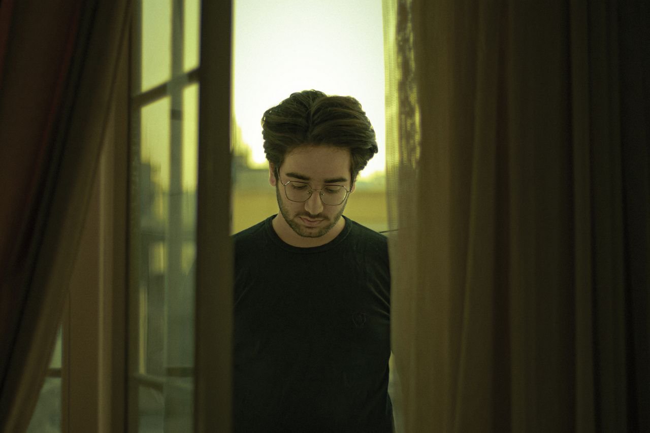 man-in-black-crew-neck-long-sleeve-shirt-standing-near-window