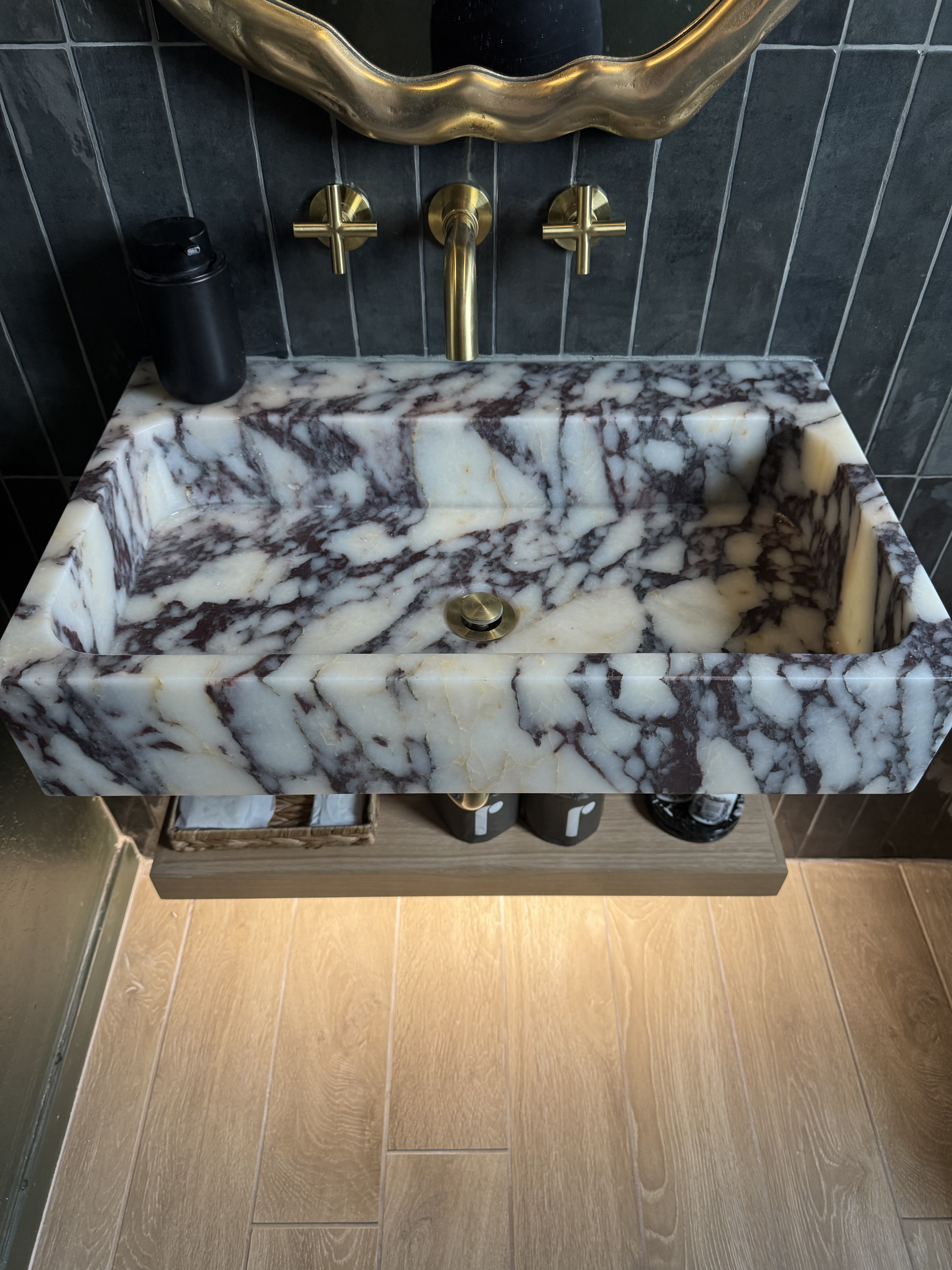 Full powder room view showing dramatic moody green walls