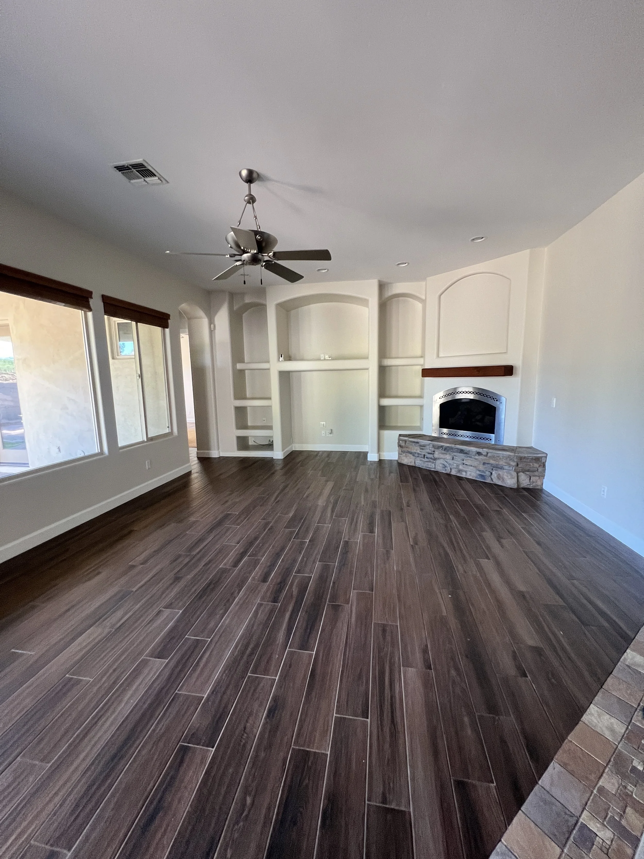 Living room before renovation with dated built-ins and corner fireplace