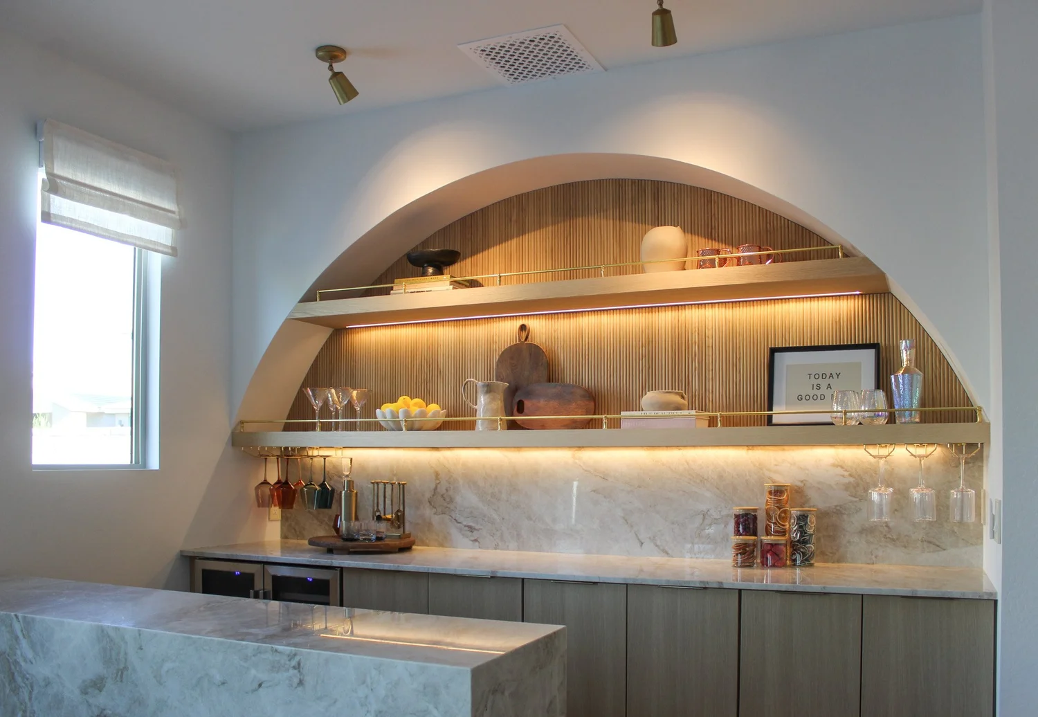 Custom arched shelving detail with brass gallery rails