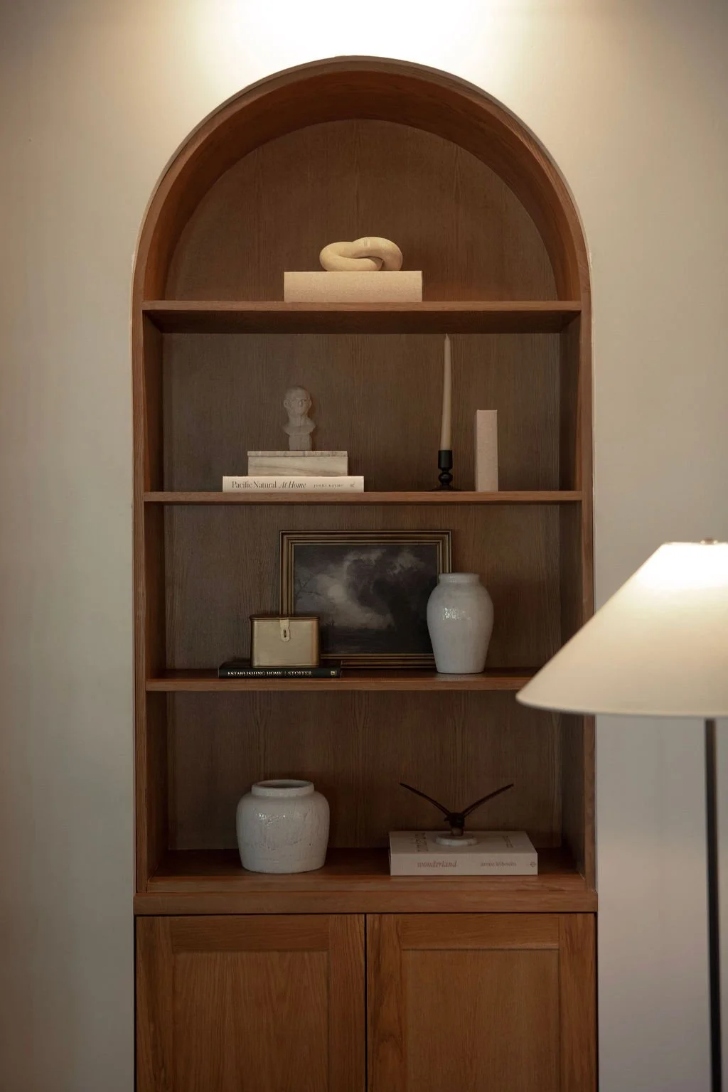 Custom arched white oak millwork with integrated shelving