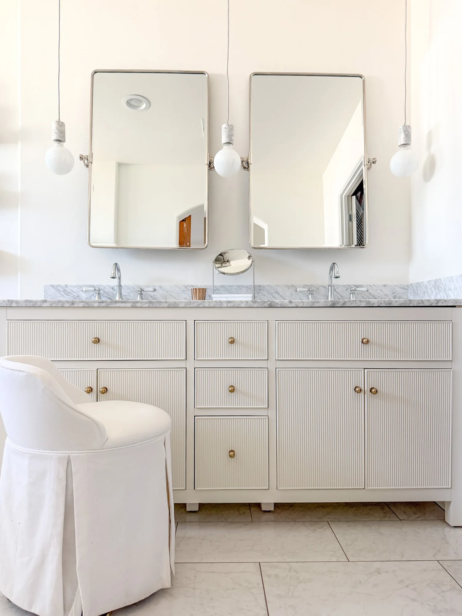 Coastal casual bathroom with reeded cabinetry and soft marble