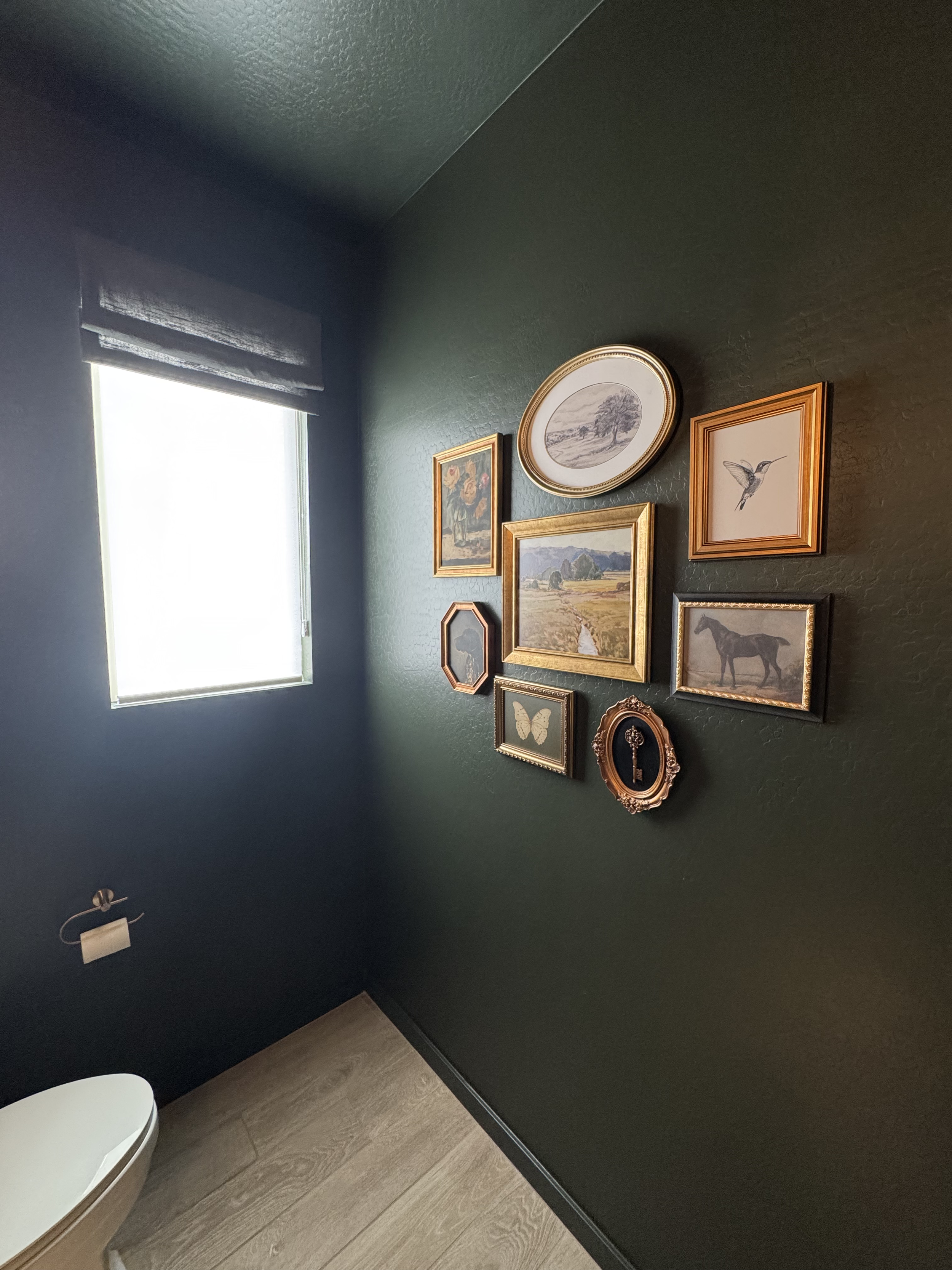 Edgy powder room mirror with black frame and towels—green bathroom trends 2025