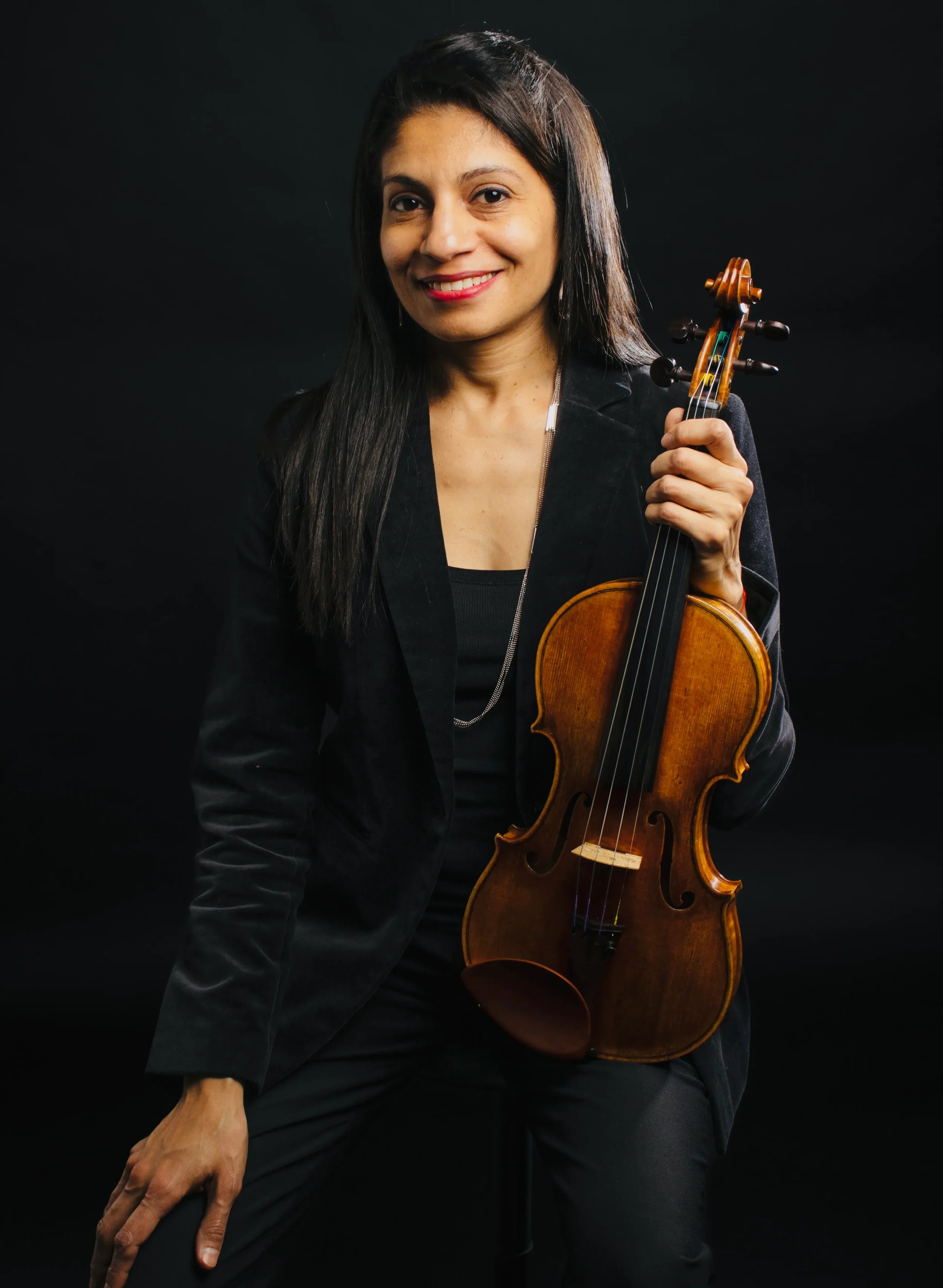 Portrait of Nelly Guevara, violinist and educator, holding her violin