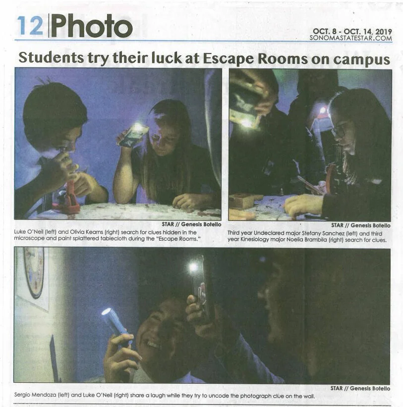 Students experimenting with microscopes and flashlights in a dark room, searching for clues in an escape room activity.