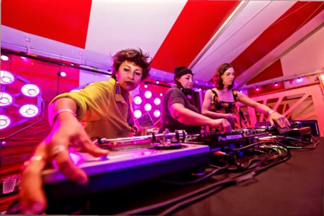 DJ Raquiqui performing a vinyl DJ set at an event in Austin, Texas blending Latin, disco, soul, and house music.