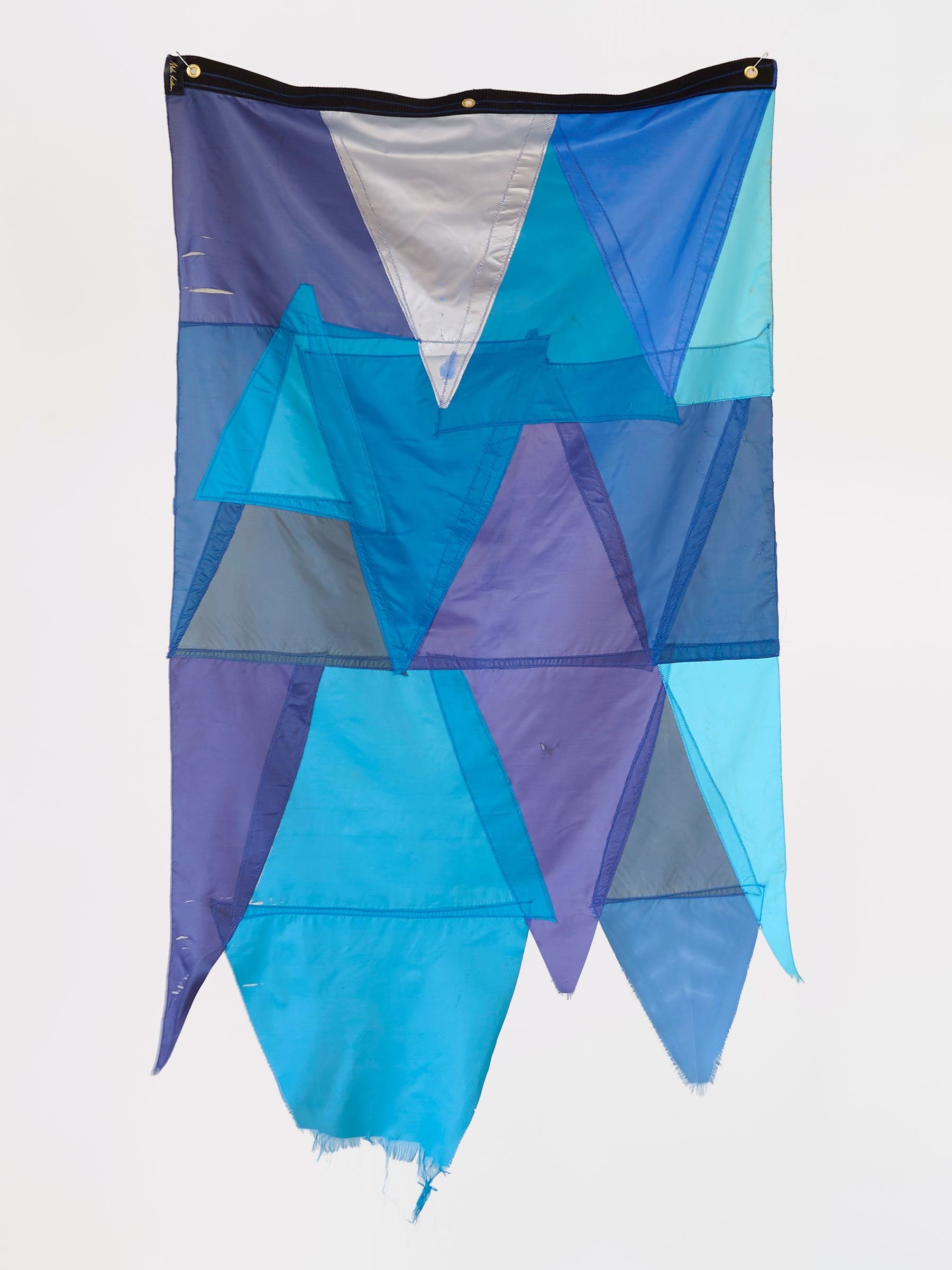 Waste Not Want Not Waterway, wall-mounted textile work of layered blue and purple umbrella fabric arranged in geometric shapes, alternate view