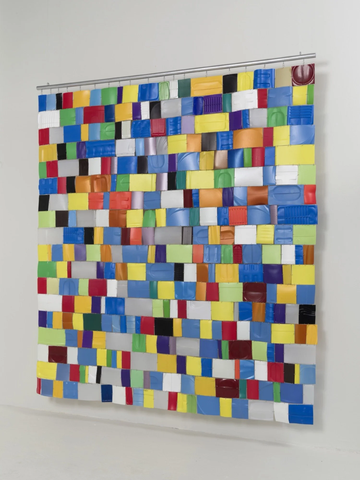 Multicolored recycled plastic bottles, wire fasteners, wood dowel, acrylic paint.