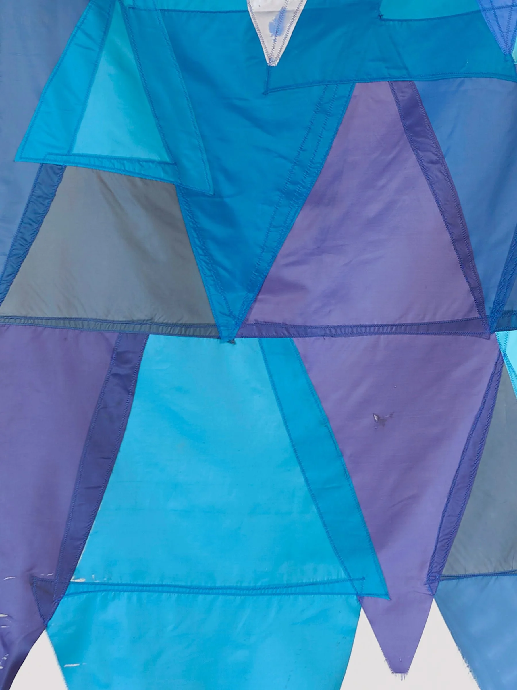 Waste Not Want Not Waterway, detail view of wall-mounted textile work of layered blue and purple umbrella fabric arranged in geometric shapes