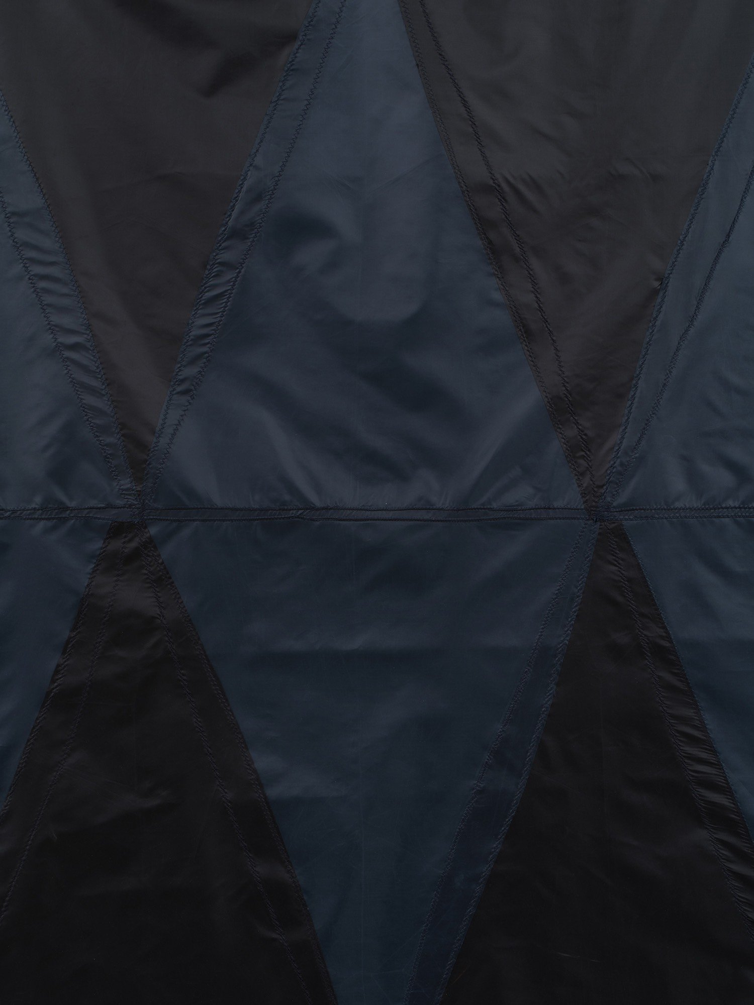 Hanging sculpture made of dark colored umbrella canopies, nylon thread, nylon webbing, grommets