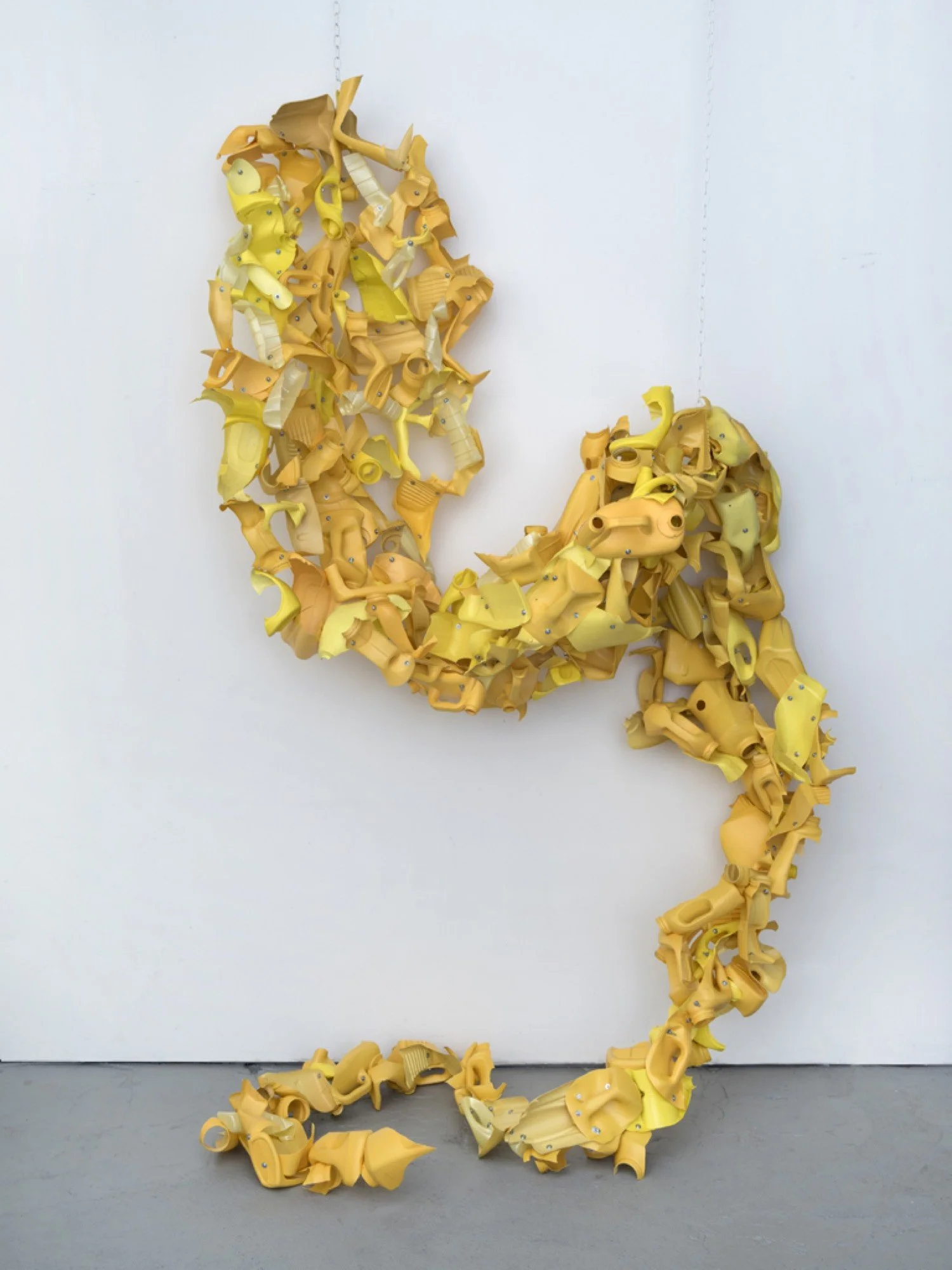 Suspended sculpture made from Arm & Hammer and corn oil bottles, machine screws, hex nuts, and nylon rope