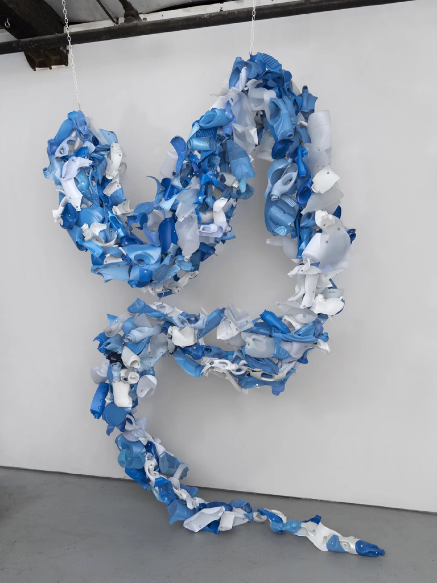 Installation view of suspended sculpture made from Downey, Ajax, vinegar, Suavitel fabric softener bottles, machine screws, hex nuts, and nylon rope