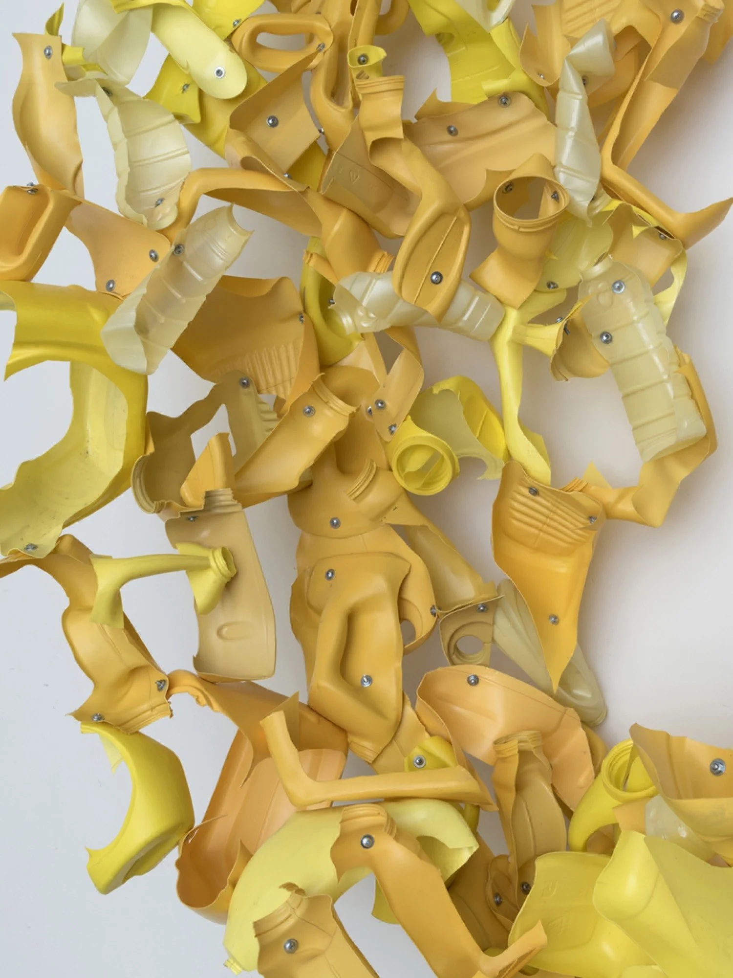 Detail of suspended sculpture made from Arm & Hammer and corn oil bottles, machine screws, hex nuts, and nylon rope