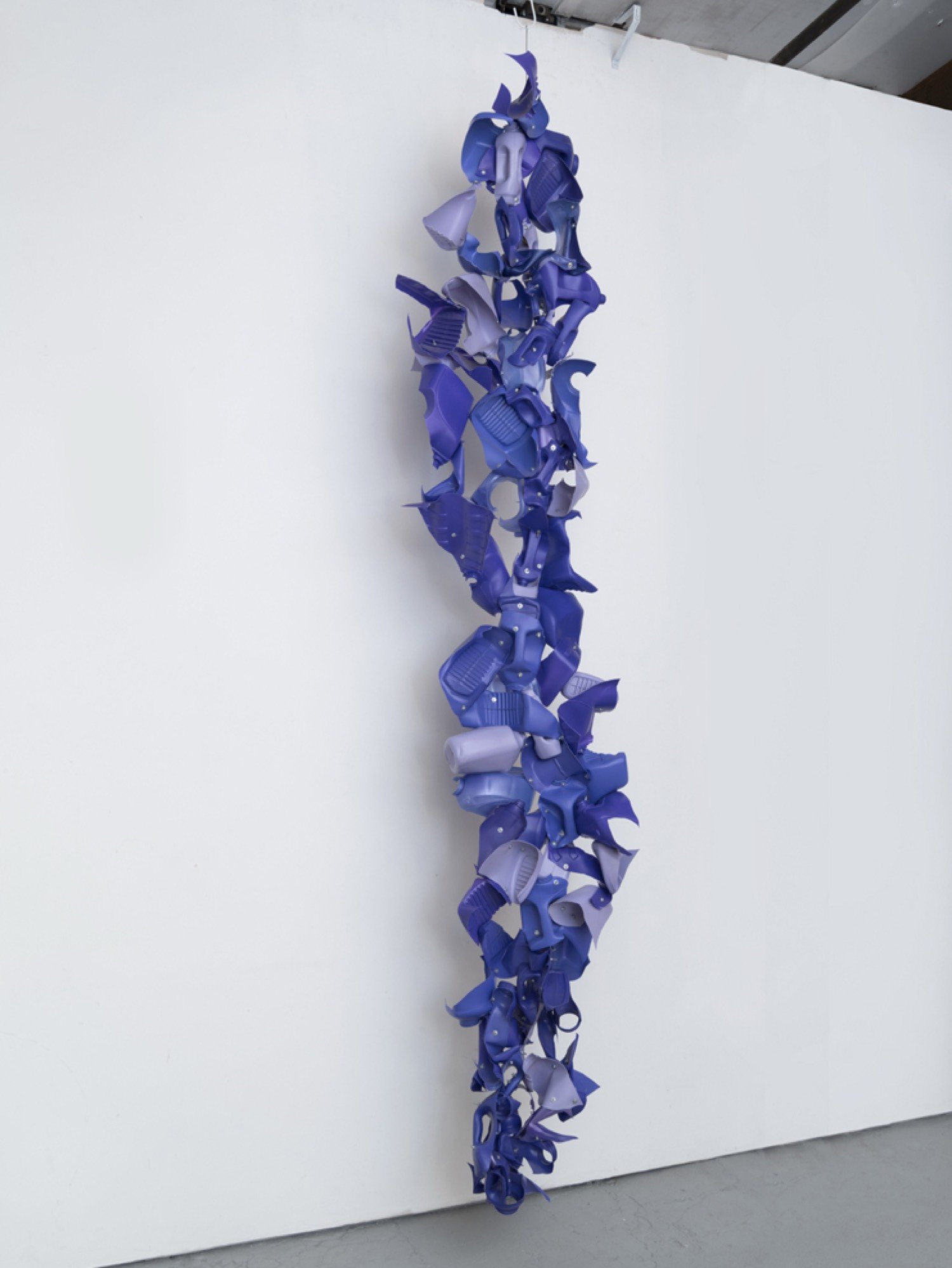 Suspended sculpture made from Suavitel, Xtra Tropical Passion, and Vaska natural detergent bottles, machine screws, hex nuts, and nylon rope.