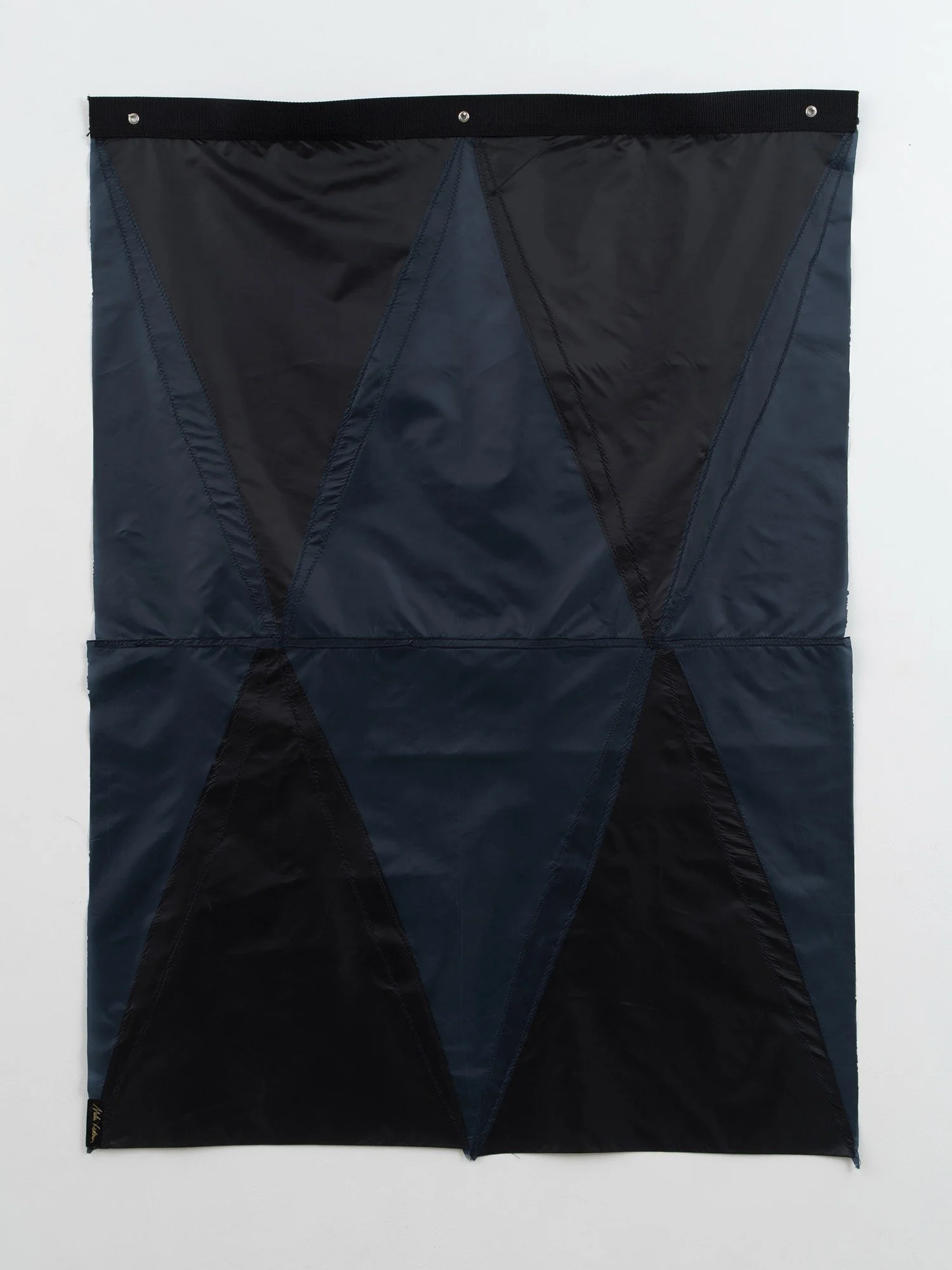 Hanging sculpture made of dark colored umbrella canopies, nylon thread, nylon webbing, grommets