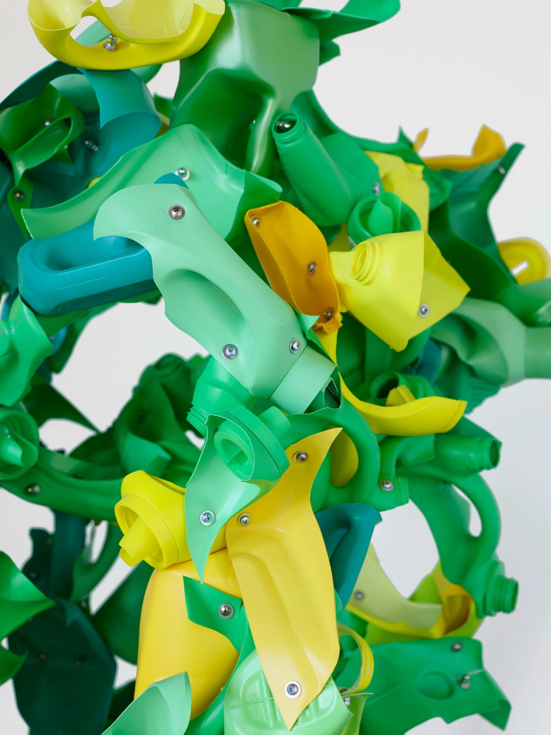 Introduced Species Yellow and Green, vertical sculpture of repurposed plastic pieces in green and yellow with complex branching forms