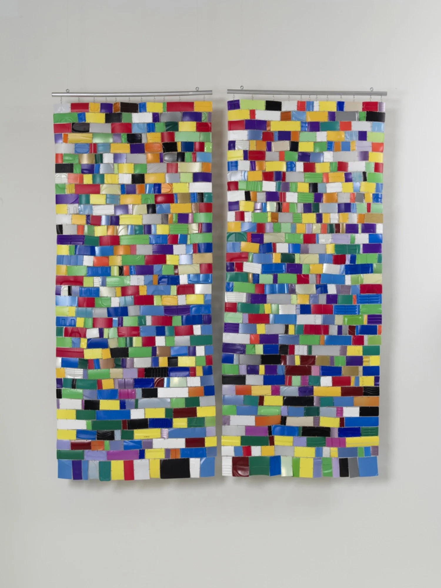 Hanging wall sculpture of colorful repurposed plastic.