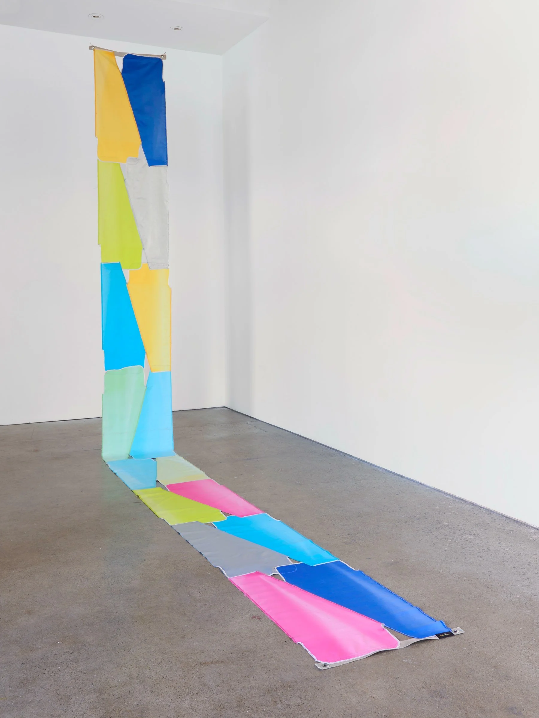 Beach Rio Bingo, suspended installation of long vertical strips of colorful umbrella fabric extending from ceiling to floor