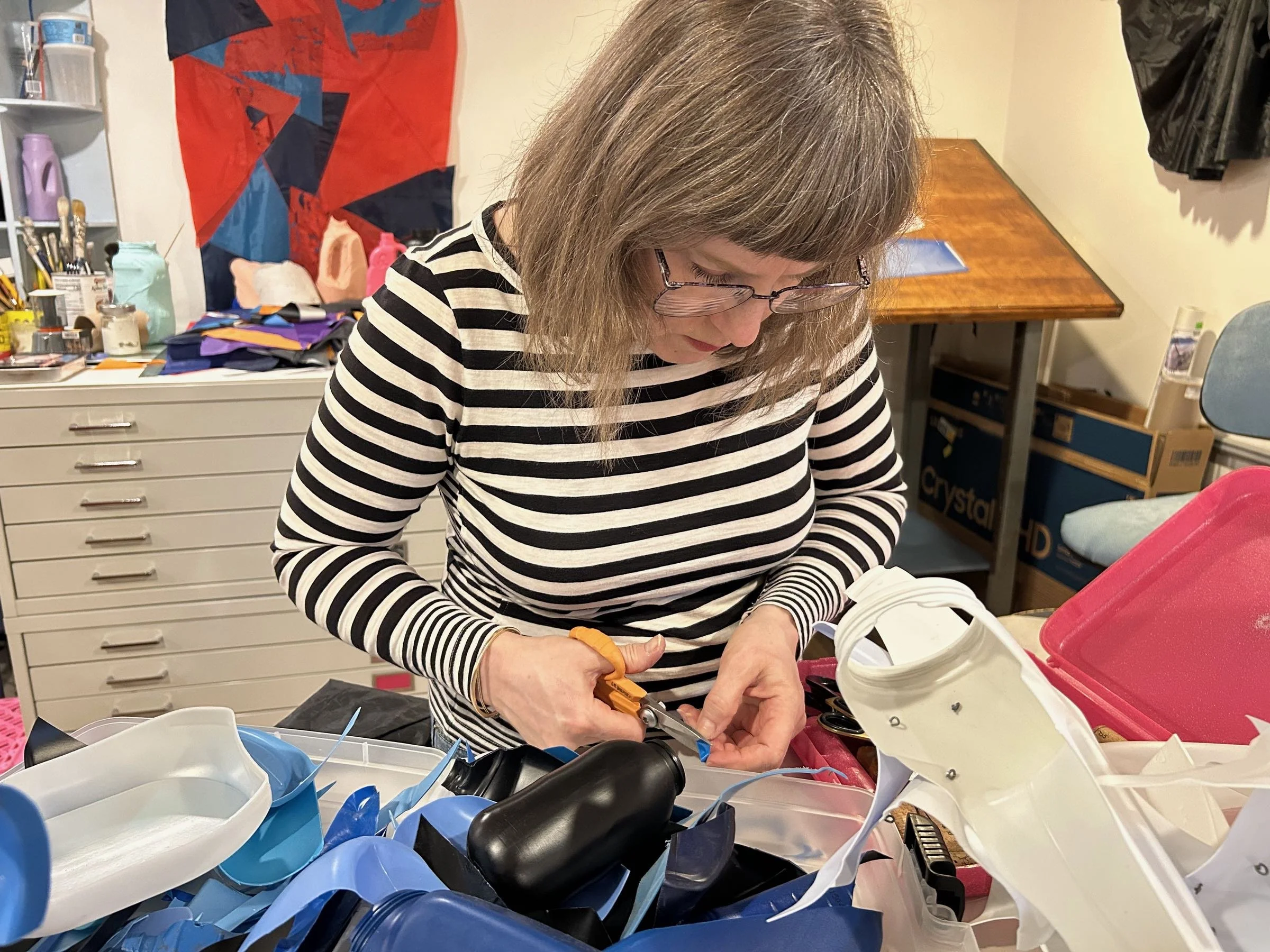 Niki Leder in the studio working with scissors.