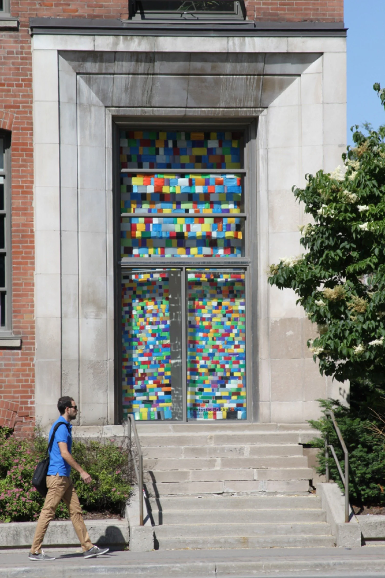 Installation view of hanging wall sculpture of colorful repurposed plastic.