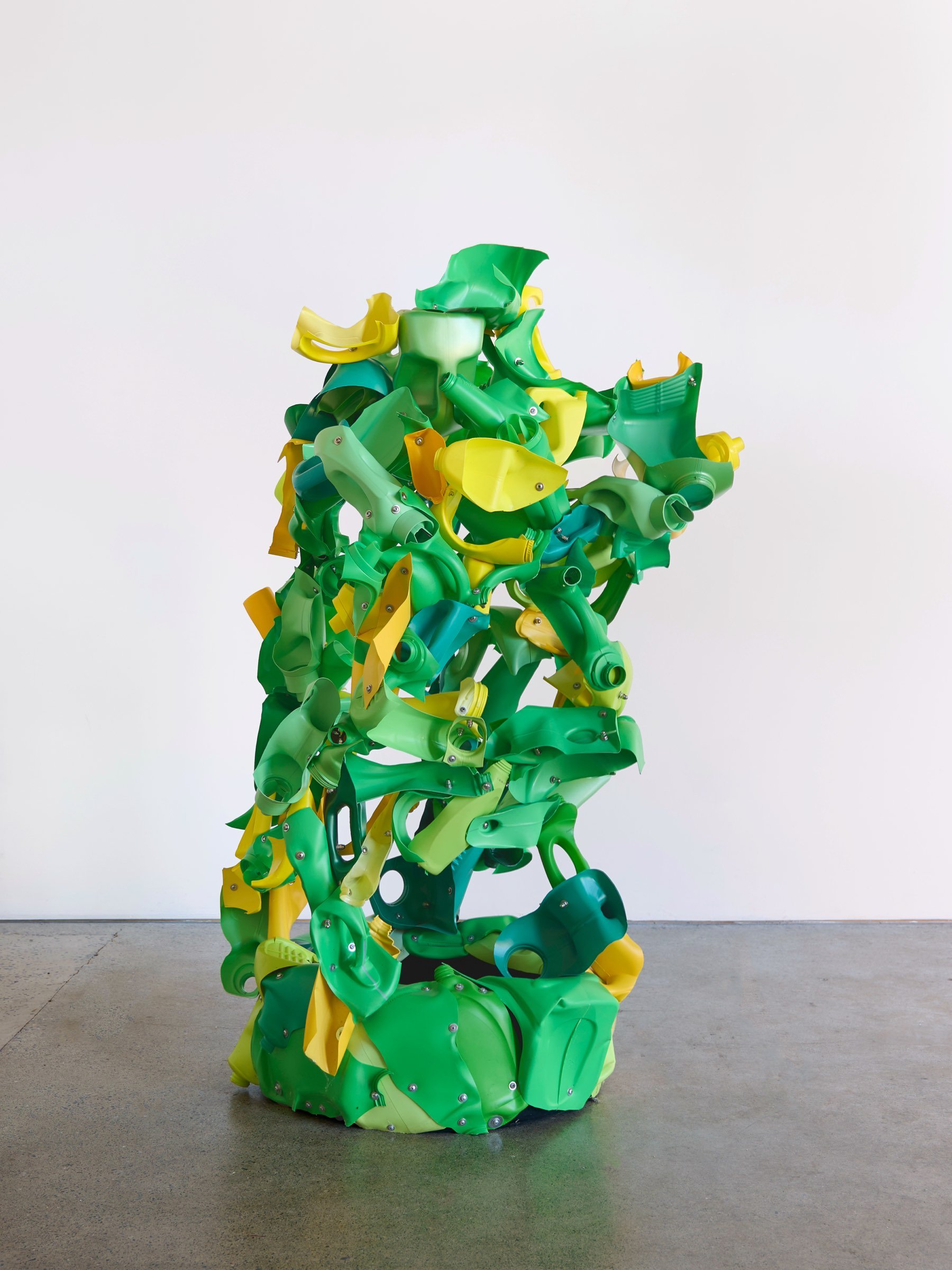 Introduced Species Yellow and Green, vertical sculpture of repurposed plastic pieces in green and yellow with complex branching forms