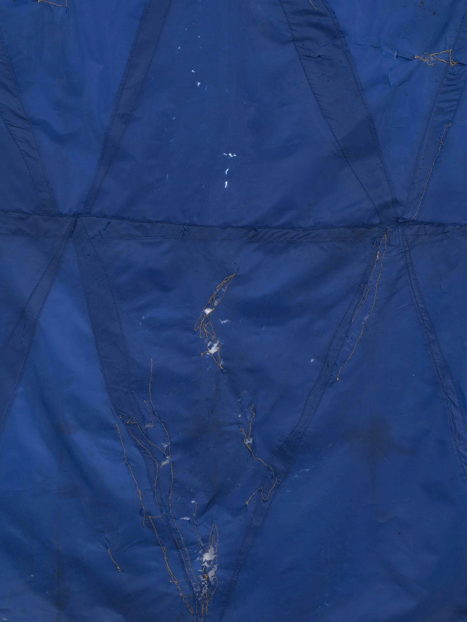 Hanging sculpture made of dark colored umbrella canopies, nylon thread, nylon webbing, grommets