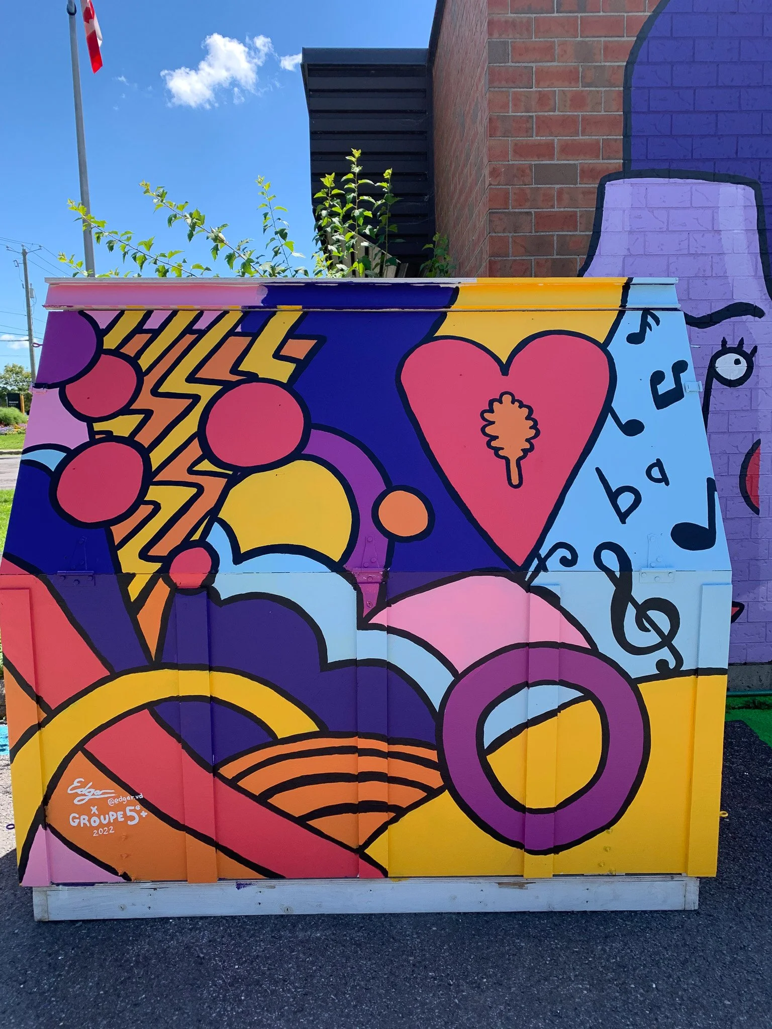 Murale colorée avec motifs géométriques, cœur rouge, notes de musique, et formes abstraites.