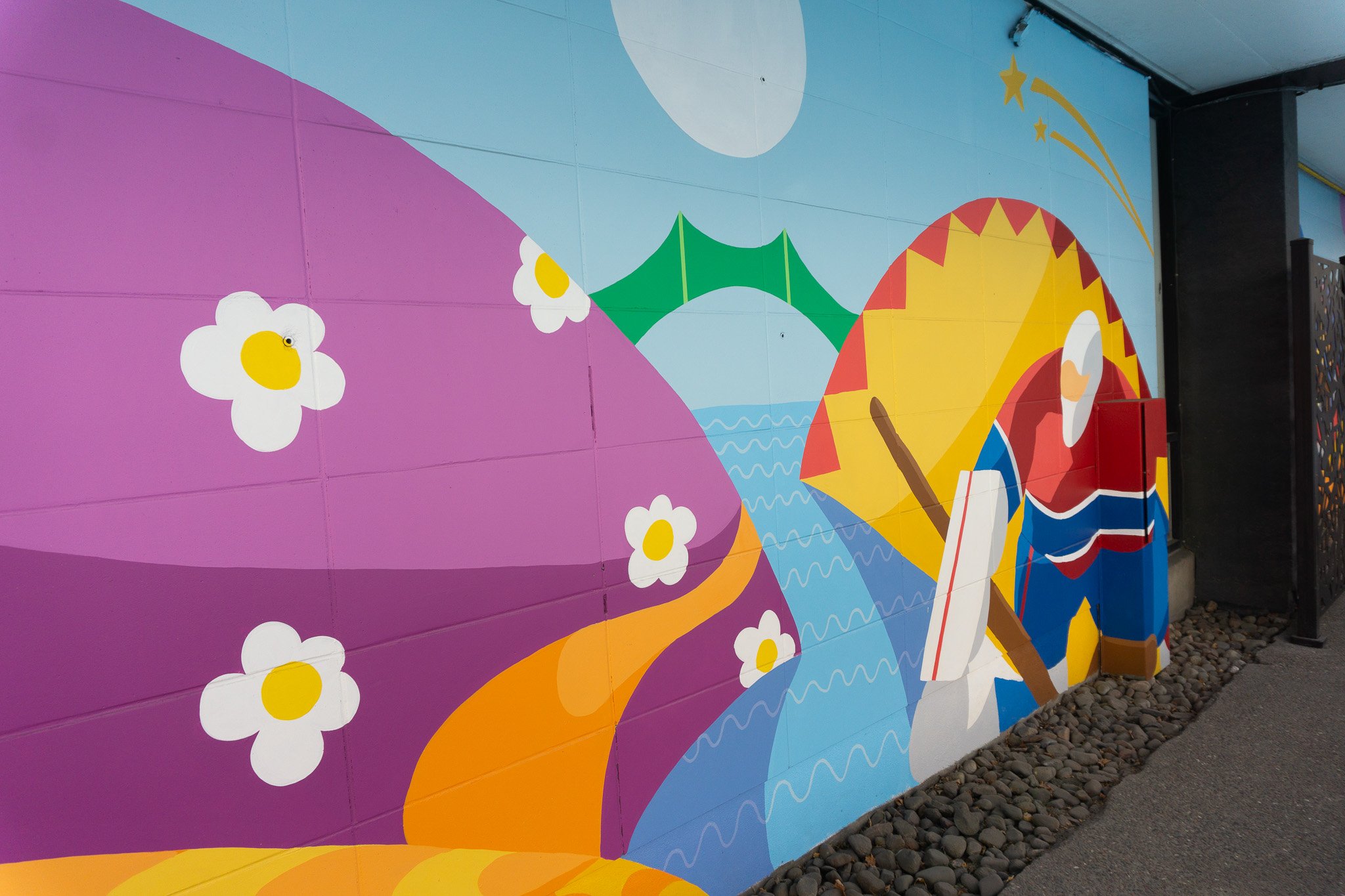 Fresque colorée fait par edgar vachon-desautels pour l'hotel ruby foo's à montréal avec fleurs blanches sur fond violet, rivière bleue, pont vert, gardien de but des canadiens de montreal.